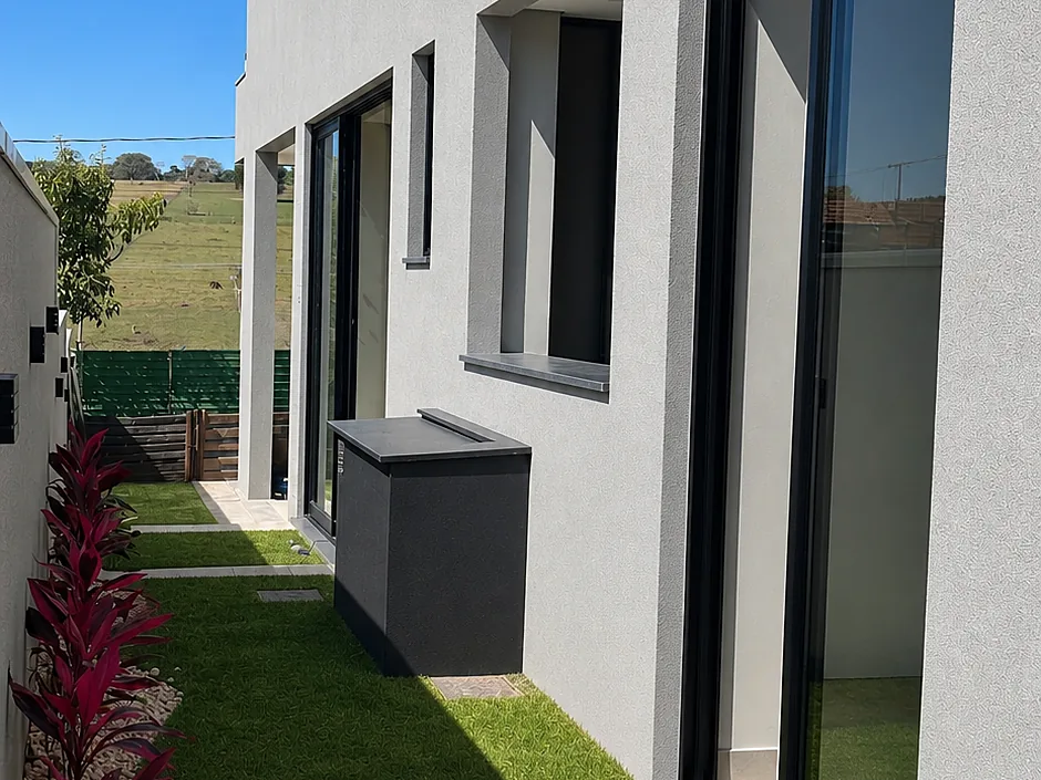 Residência com fachada clara e jardim lateral, padrão MV Engenharia